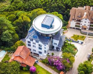 an aerial view of a house with a solar roof at HOTEL RF VISION restaurante giratório in Gramado