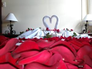 ein Bett mit roter und weißer Bettwäsche und zwei Schwänen in der Unterkunft Club Tejamaniles in Los Azufres
