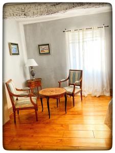 a living room with a table and two chairs and a window at La Providence in Apt