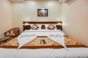 1 dormitorio con cama blanca con mando a distancia en HOTEL SJ PRIDE, en Bhubaneshwar