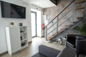 a living room with a couch and a staircase at Casas da Barca in Vila Nova de Foz Coa