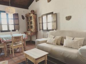 uma sala de estar com um sofá e uma mesa em La casita del hortelano em Robledo de Chavela