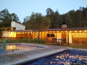 a backyard with a pool and a house with lights at Club Tejamaniles in Los Azufres