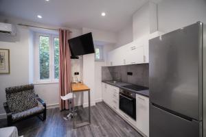 a kitchen with a refrigerator and a table and a chair at Studio Reale Corfu in Corfu +2 photos