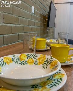 a table with plates and cups on a table at Edificio La Alameda in Cali