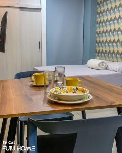 une table en bois avec deux tasses et une assiette sur elle dans l'établissement Edificio La Alameda, à Cali