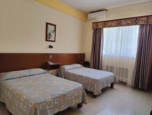 a hotel room with two beds and a window at Hotel Pekin in La Paz