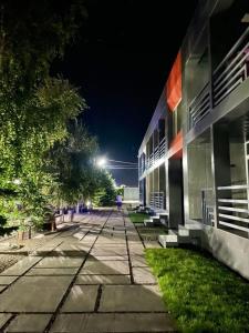 een lege straat voor een gebouw 's nachts bij Гостевой Комплекс ARTек in Tamchy