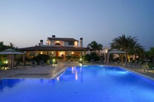 a large swimming pool in front of a house at Ferrocino Resort in Galatone