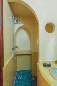 a bathroom with a shower with a tile floor at Noqta Space Coworking Coliving Space in Essaouira