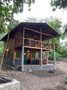 a large wooden house with a balcony on top of it at Mucumbli in Ponta Figo