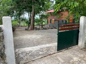 ein grünes Tor vor einem Gebäude in der Unterkunft Mucumbli in Ponta Figo