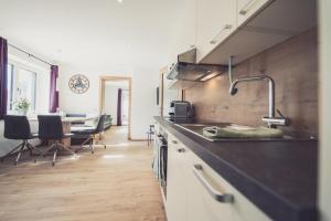 a kitchen with a sink and a table with chairs at Apartments z‘Haus in Sankt Gilgen