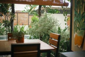 um quarto com mesa, cadeiras e plantas em El Hábita CASA SELVA em Santa Teresa