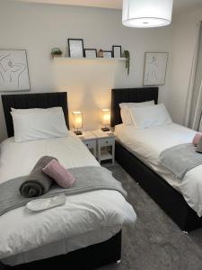 two beds sitting next to each other in a bedroom at Salisbury Suite - Modern 2 bedroom flat with parking in Menai Bridge in Menai Bridge