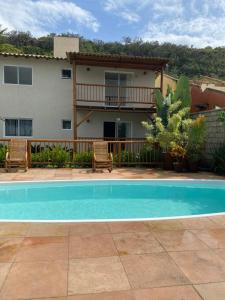 a house with a swimming pool in front of a house at Flat Beira Mar Porto Segur in Porto Seguro