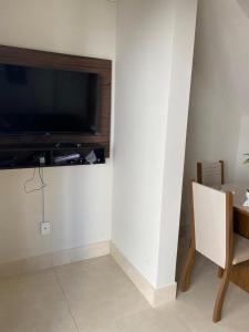 uma sala de estar com uma televisão de ecrã plano na parede em Flat Beira Mar Porto Segur em Porto Seguro