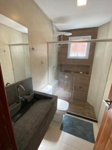 a bathroom with a tub and a toilet and a window at Flat Beira Mar Porto Segur in Porto Seguro