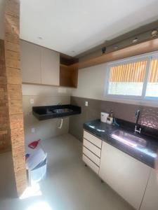a small kitchen with a sink and a window at Flat Beira Mar Porto Segur in Porto Seguro