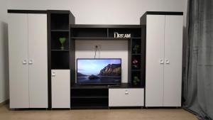 a tv in a entertainment center with white cabinets at Garsoniera 30mp ChrysFlatty 1 in Arad