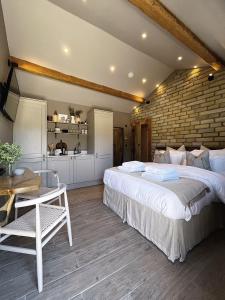 um quarto com uma cama grande e uma parede de tijolos em Apartments for two in Brand New Luxury Rural Farmhouse Escape em Ramsbottom