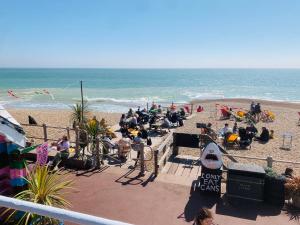a group of people sitting on the beach at Super King, Close to Beach, Shops, Train, Shared Bathroom in St. Leonards