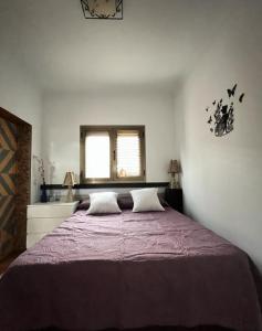 a bedroom with a large bed with a purple blanket at Casa vacacional Renacer in Gran Tarajal
