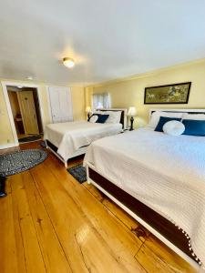 two beds in a bedroom with wooden floors at Clark Currier Inn in Newburyport