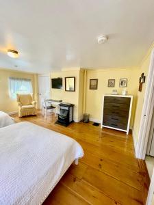 a bedroom with a bed and a table with a chair at Clark Currier Inn in Newburyport