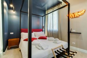 1 dormitorio con cama con dosel y almohadas rojas en VIVILO ROMA TREVI - LUXURY EXPERIENCE - PRIVATE JACUZZI on TERRACE - INSANE VIEW en Roma