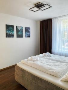 a bedroom with a bed with white sheets and a window at Cozy Apartment Bernburg 1 in Roschwitz