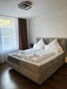 a bed with white sheets and pillows in a bedroom at Cozy Apartment Bernburg 1 in Roschwitz