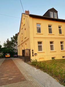 a yellow building on the side of a street at Cozy Apartment Bernburg 1 in Roschwitz
