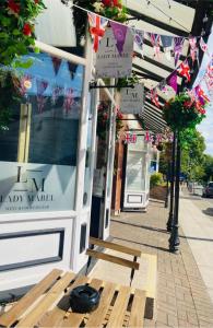a bench sitting in front of a shop with flags at InstaLet Apartments I Wigan Central I Free Parking in Wigan