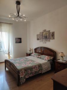una camera con letto e lampadario a braccio di Mi casa es su casa a Cividale del Friuli