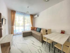 a living room with a couch and a table at Green Paradise Complex in Primorsko