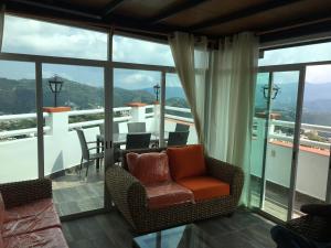 阿拉爾孔塔斯科的住宿－Casa Vista hermosa de taxco，客厅设有带桌椅的阳台