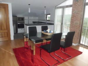 Apartment Valle de Cepeda في Cepeda: مطبخ مع طاولة سوداء وكراسي سوداء