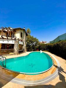a large swimming pool in front of a house at Villa Mor Fethiye in Fethiye