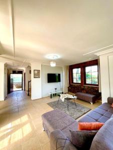 a living room with a couch and a tv at Villa Mor Fethiye in Fethiye