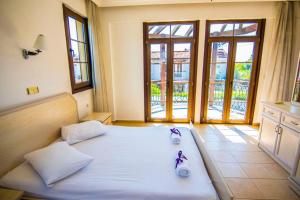 a large bed in a room with windows at Villa Mor Fethiye in Fethiye