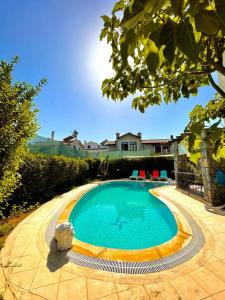 a swimming pool in a yard with a house at Villa Mor Fethiye in Fethiye