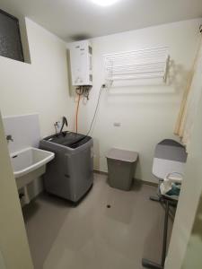 a bathroom with a sink and a trash can at Departamento Miraflores del Jardín. in Cajamarca