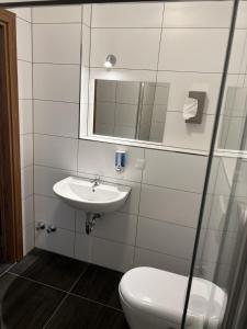 a bathroom with a sink and a toilet and a mirror at Hotel Pasa Paradies KOSTENLOSE PARKPLÄTZE in Hanau am Main