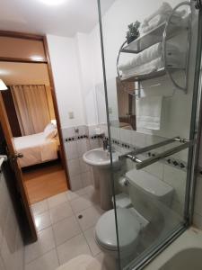 a bathroom with a toilet and a sink at Departamento Miraflores del Jardín. in Cajamarca