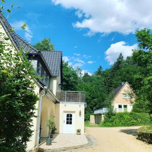 a white house with a balcony on top of it at Kuckuckswinkel- Ferienwohnung Lilian in Schöna