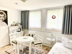 a white living room with a table and chairs at Kuckuckswinkel- Ferienwohnung Lilian in Schöna +14 photos