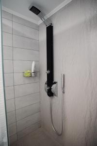 une douche avec un tuyau fixé à un mur dans l'établissement Olympia apartments Heraklion center, à Héraklion