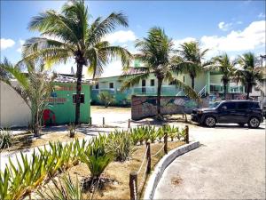 a truck parked in a parking lot with palm trees at pousada costa do meio in Saquarema