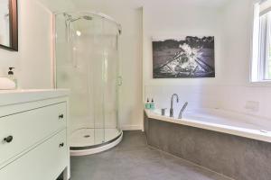 a bathroom with a shower and a tub and a sink at 4 Storey Ski Inout Mountain Home In Tremblant in Mont-Tremblant +43 photos
